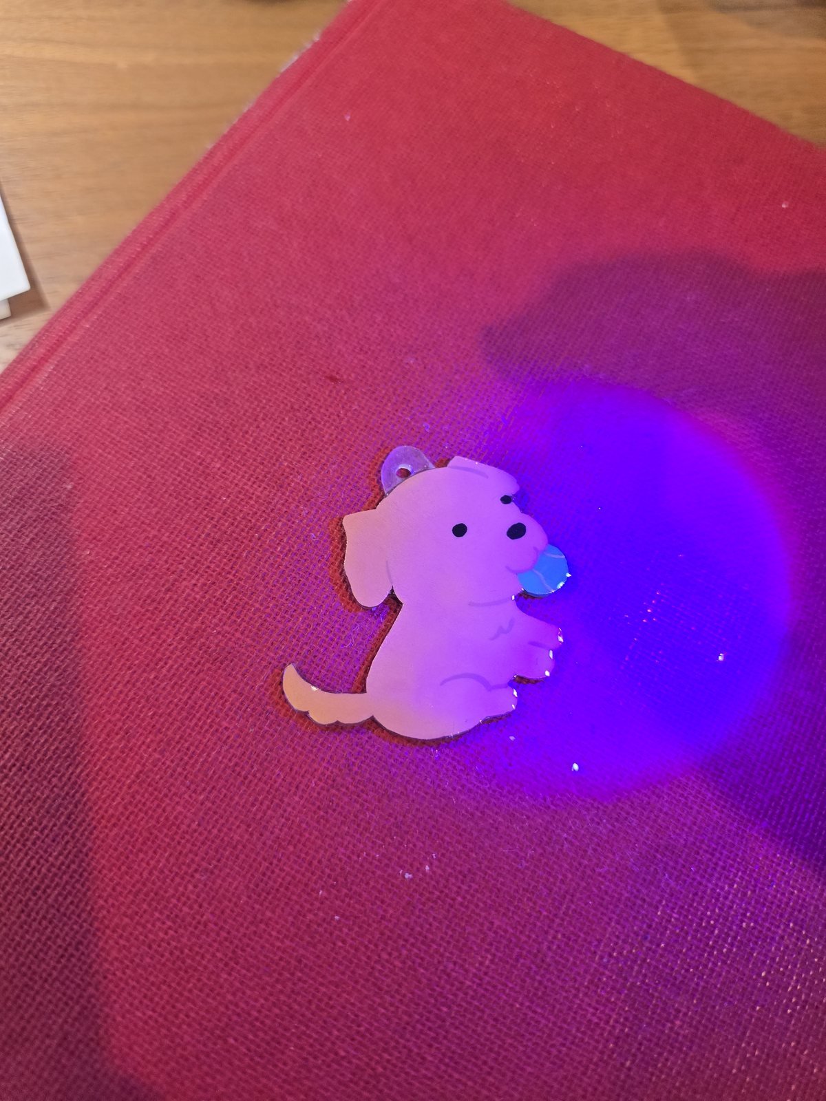 The charm under a UV lamp, curing the protective gel coating