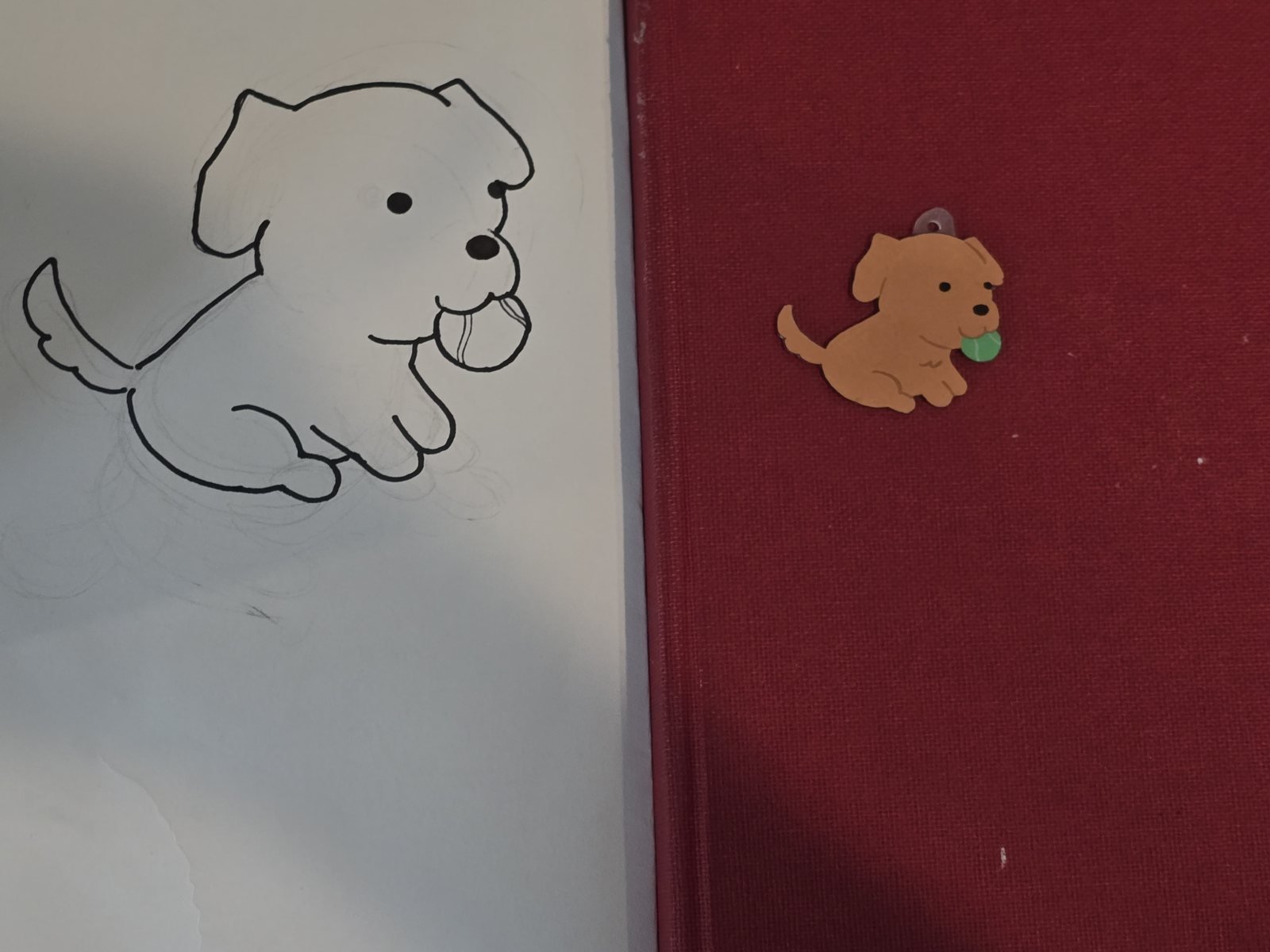 The pencil-and-Sharpie sketch next to the finished glossy charm it became